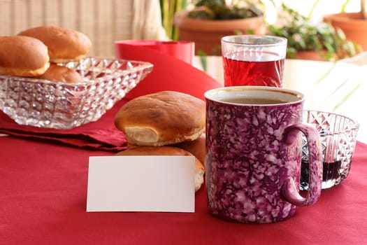 Tea with a roll and jam with an empty card for messages.
