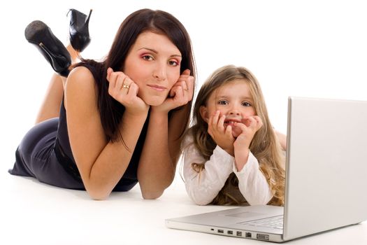 Young mother teaching her daughter how to use laptop and internet