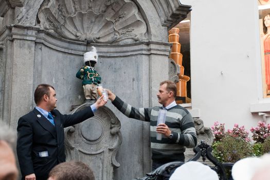 BRUSSELS - OCTOBER 3: Manneken Pis dressed in uniform of Fanfare Royale de Moulbaix-Ligne and urinating beer, Brussels, Belgium October 3, 2009