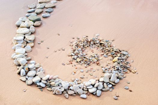 Spiral of gravel on the surface of the sand