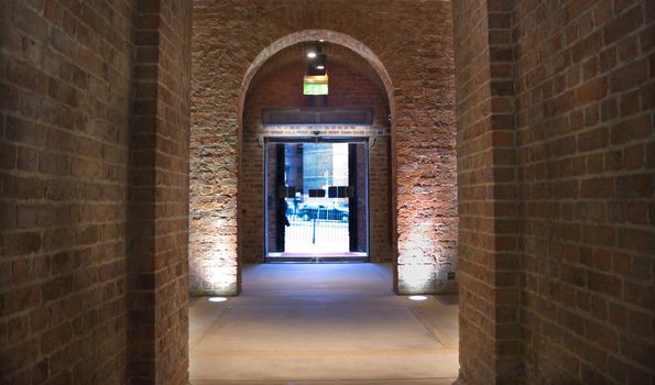 Looking through ancient arch towards modern glass exit door