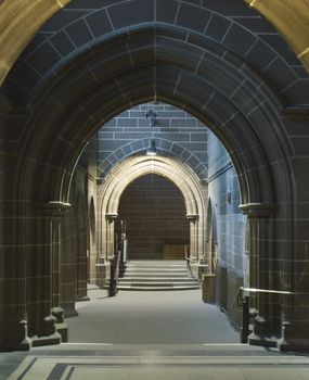 Looking through a series of arched sandstone doorways in ancient cathedral