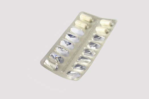 Used medicine tablet blister-pack isolated against a grey  background.