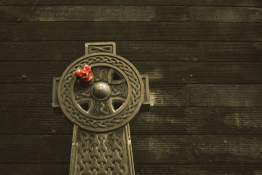 Sepia shot of monument in graveyard with a bunch of flowers