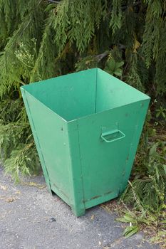 old green recycle bin in a park