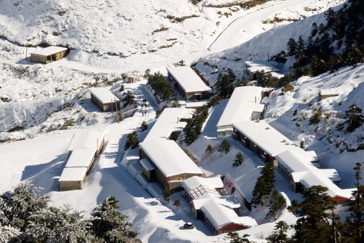 Snow town in winter with white buildings and house.