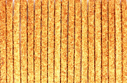 Many breadsticks with sesame seeds background