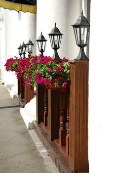 Row of black street lamps against the white columns