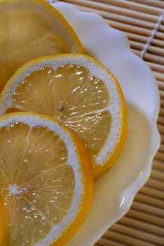 The cut slices of a lemon on a dessert plate. A close up.