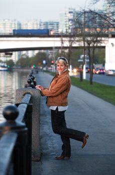 Smiling woman stands on coastline of the river