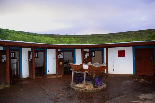 A photograph of stables with an ecologically sound 'green roof'