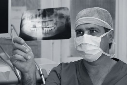 The doctor closely studying x-ray of human teeth