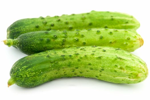 Three green cucumbers on a white background.