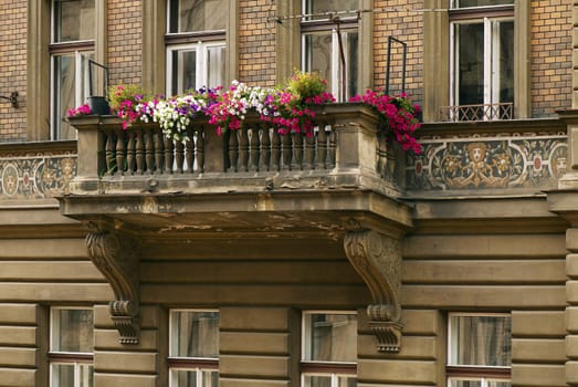 The balcony of the old house decorated by flowers