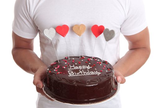 Man holding a chocolate birthday cake with lovehearts.  Closeup