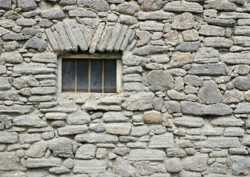 Old window by a simple stone.
