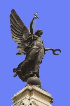 Winged statue of Victory in Colchester War Memorial. In her right hand she is holding a sword, point downwards so that it represents "The Cross of Sacrifice" and "The Sword of Devotion," and in her left a wreath of laurel. 