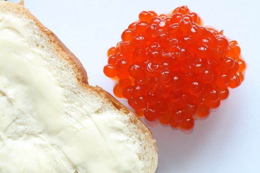 Closeup of a whole lot of red caviar near white bread and butter