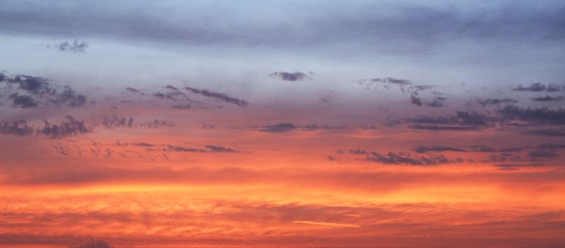 Cloudy sky with sunset colours suitable for use as a background.