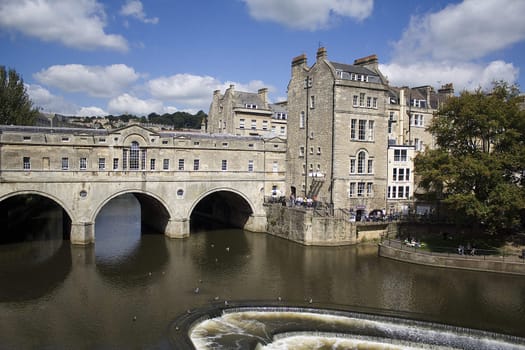 Pulteney Bridge over the river Avon in Bath, England. It is lined with shops on both sides. Georgian architecture.