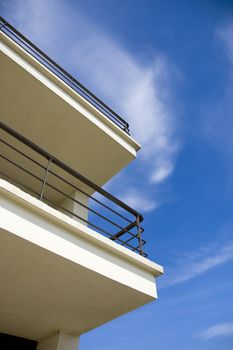 A balcony against a blue sky with some clouds