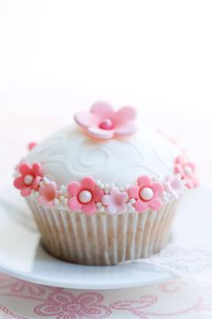 Cupcake decorated with pink and white sugar flowers