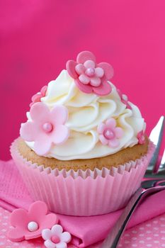 Cupcake decorated with pink fondant flowers