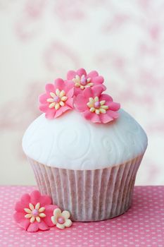 Cupcake decorated with embossed fondant and sugar flowers