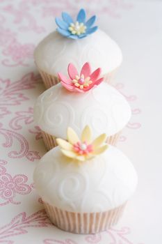 Cupcakes decorated with embossed fondant and sugar flowers