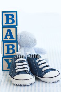 Blue denim baby shoes, baby blocks and teddy bear