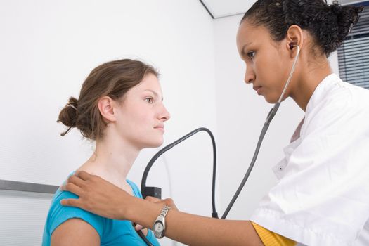 Doctor listening to the heartbeat of her patient with a stethoscope
