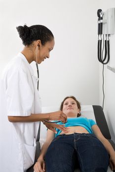 Doctor checking the abdomen of one of her patients