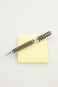 Pen on a yellow sticky pad
