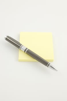 Pen on a yellow sticky pad
