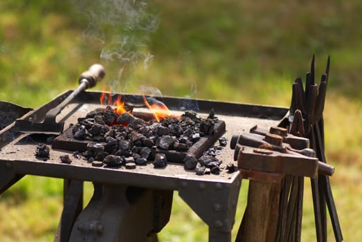 Photo of a smithy with burning coals and tools for forging