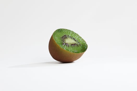 Hunk of sliced kiwi against white background.