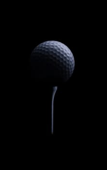 Golf ball on tee under dramatic light, agains black.