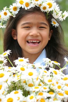 Beautiful little girl with crown of daisies