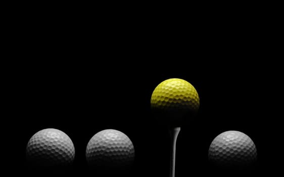 Line of golf balls, with yellow ball on tee, against black background.