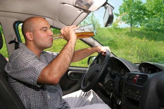 Drunk man sitting in drivers sit and drinking from a bottle