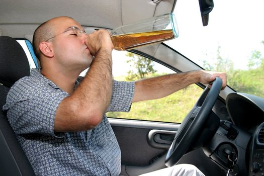 Drunk man sitting in drivers sit and drinking from a bottle