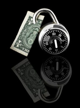 Dollar bill locked by combination lock on black background with reflection. 