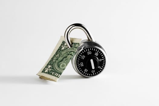 Dollar bill locked by combination lock on white background.