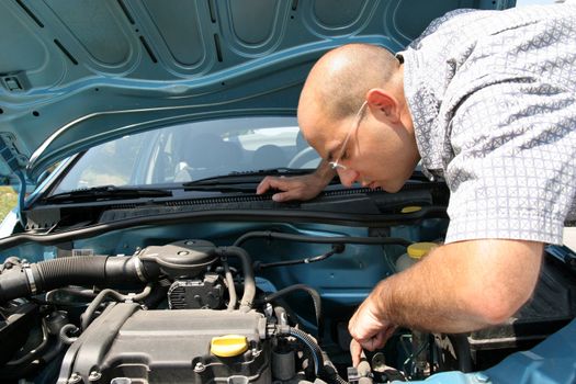 Businessman opening the trunk and checking the engine of a car