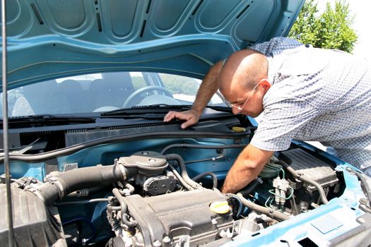 Businessman opening the trunk and checking the engine of a car