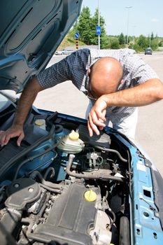 Businessman opening the trunk and checking the engine of a car