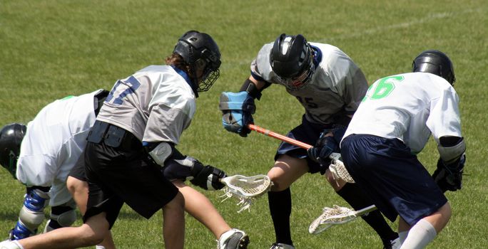 A lacrosse scrum featuring four players.