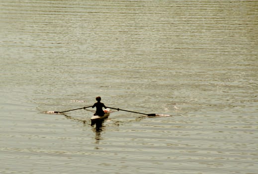 A kayaker's silhouette as they skim across the river.
