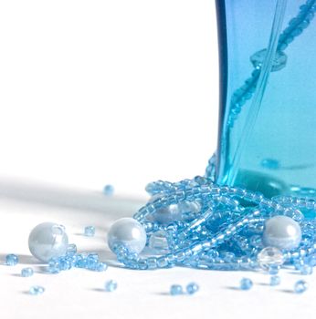 The image of a bottle with perfumery water and the scattered thread of a beads