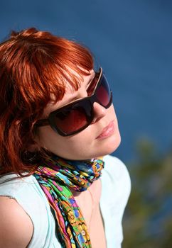 The woman with red hair enjoys the sun